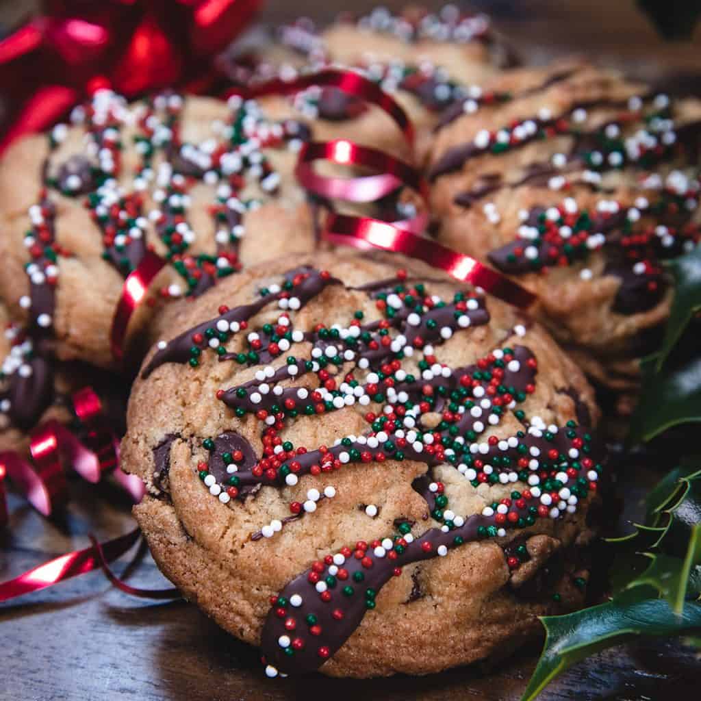 a stack of chocolate chip cookies decorated with christmas sprinkles