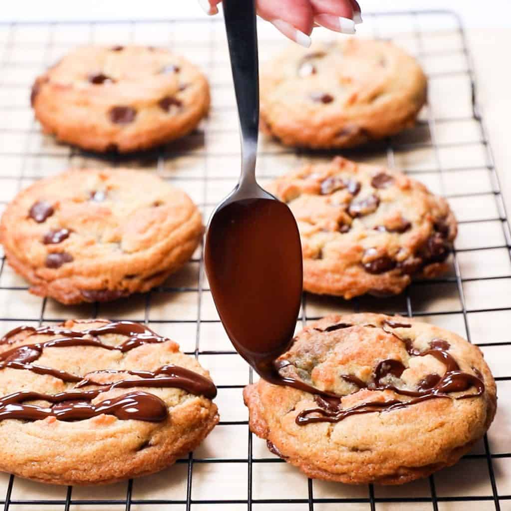 Chocolate being drizzeled over cookies with a spoon 