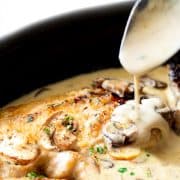 Creamy Mushroom Chicken in a skillet with a spoonful of sauce.