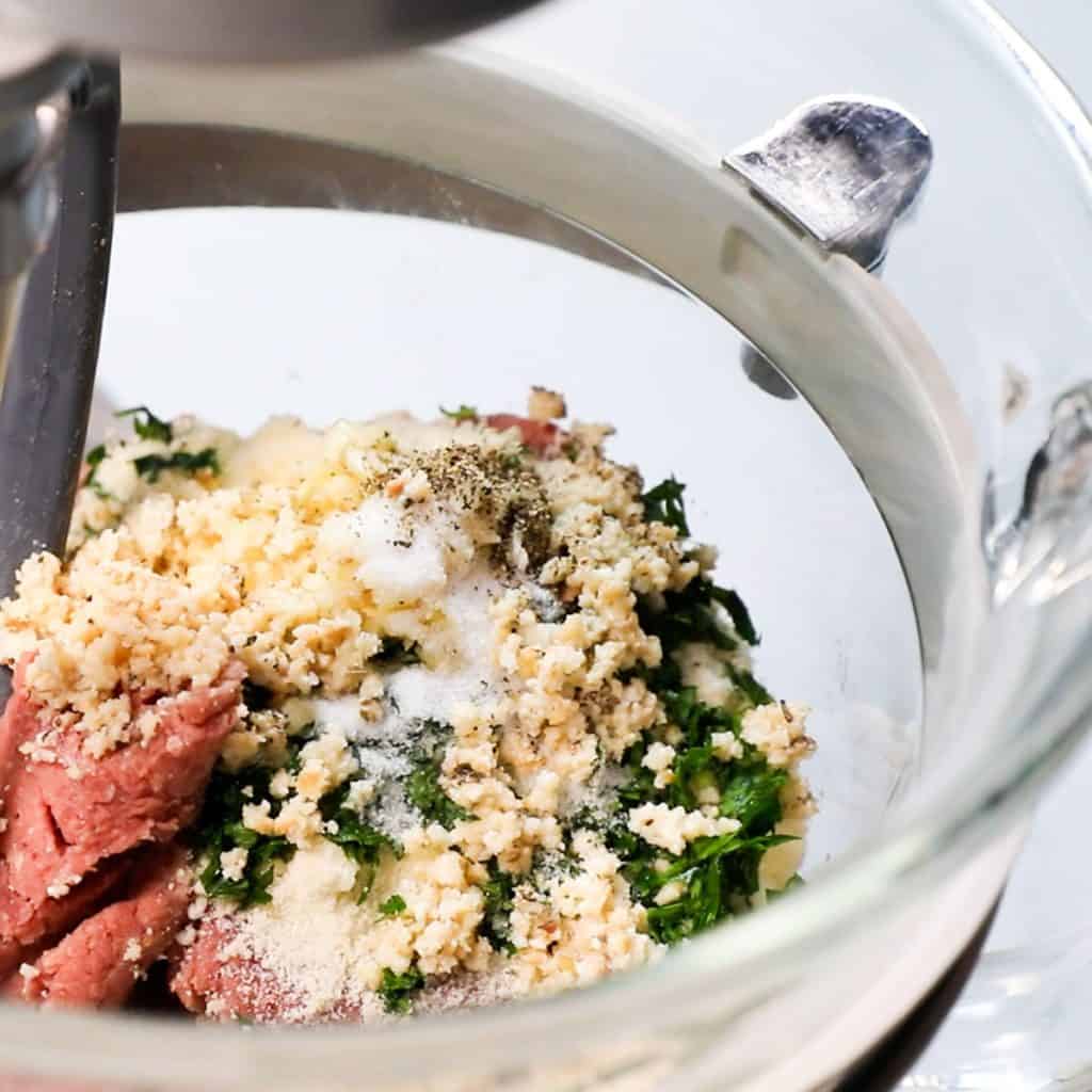 ground beef, parmesan cheese, garlic and herbs in a bowl