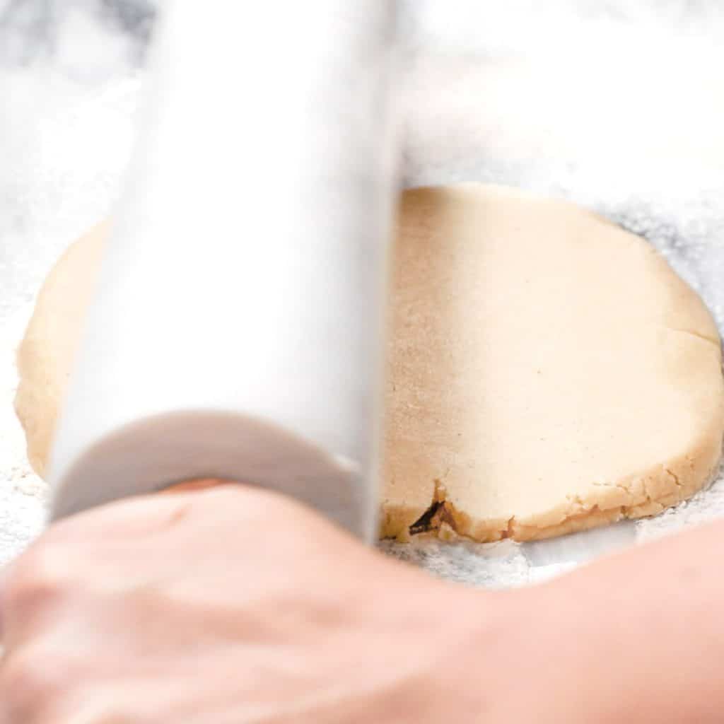 pie crust being rolled out with a rolling pin