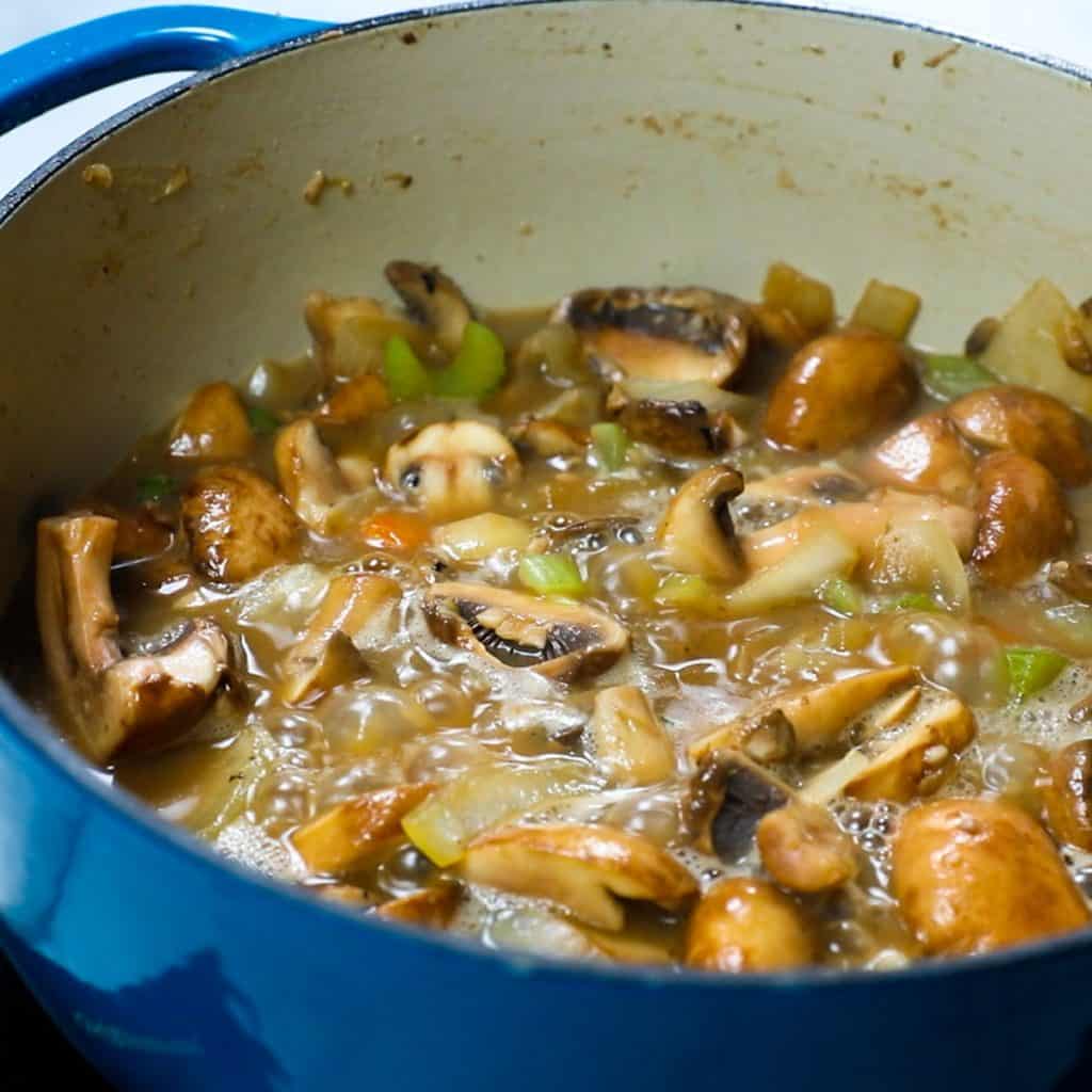 wine bubbling in the pan with the mushroom mixture