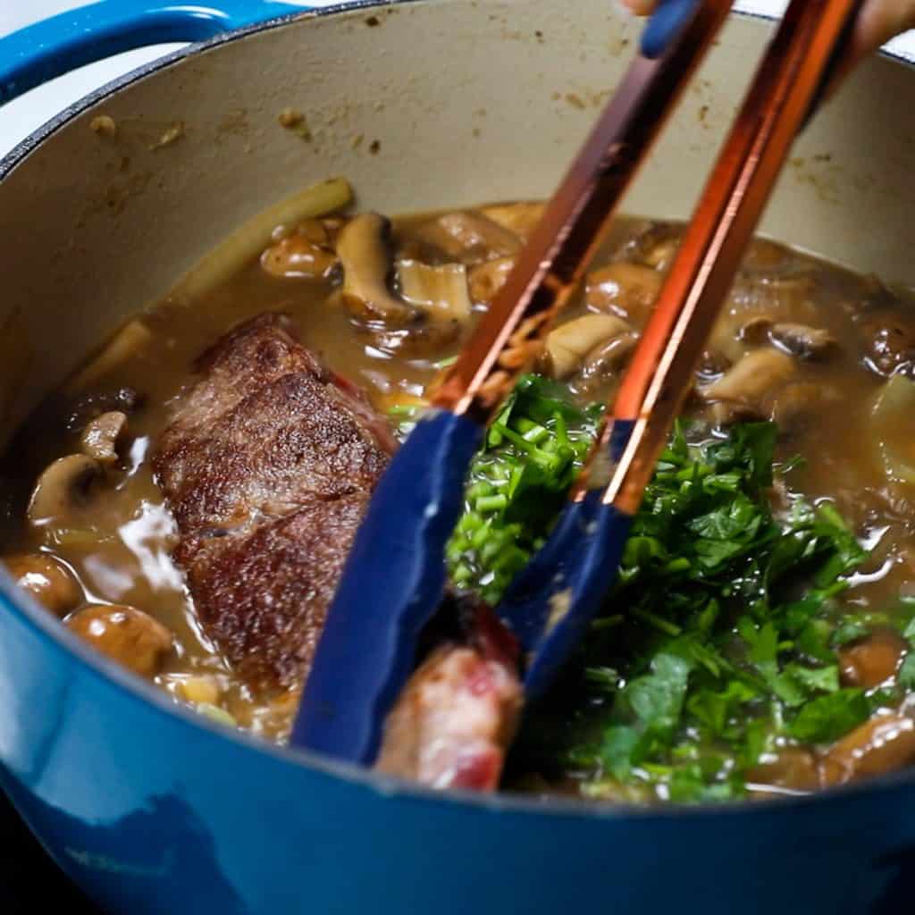 The beef being added to the pan with the sauce