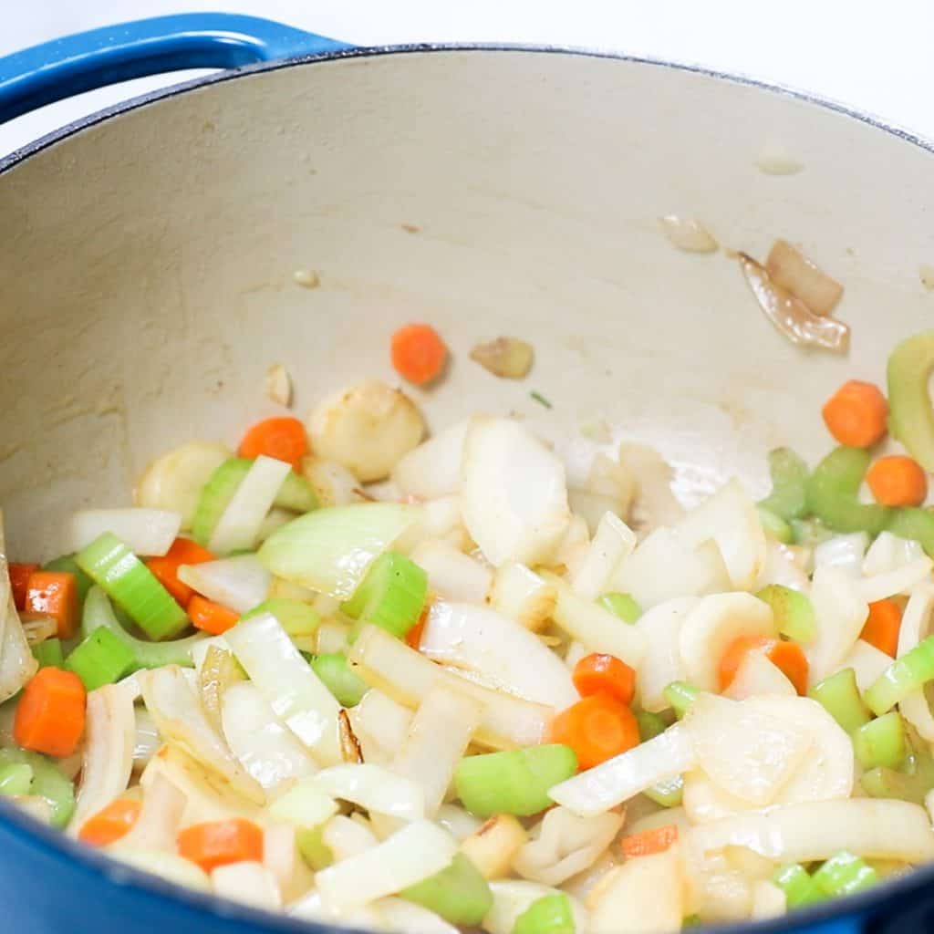 onions, celery and carrots cooking in a pan