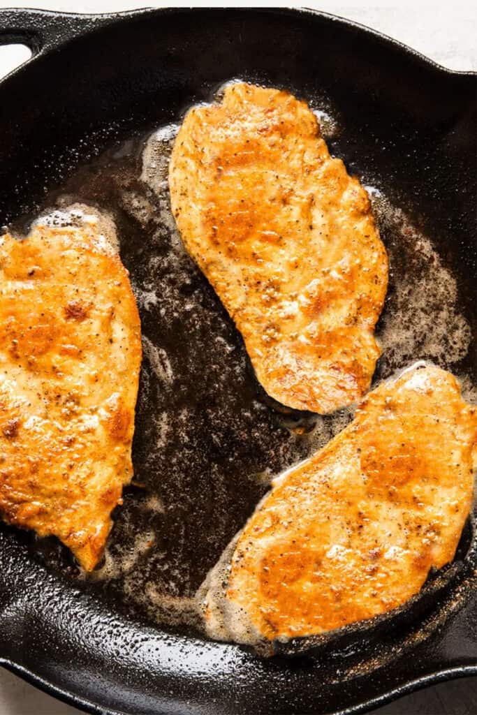 breaded chicken frying in a pan