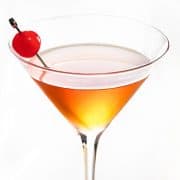 a cocktail glass with manhattan drink and a cherry