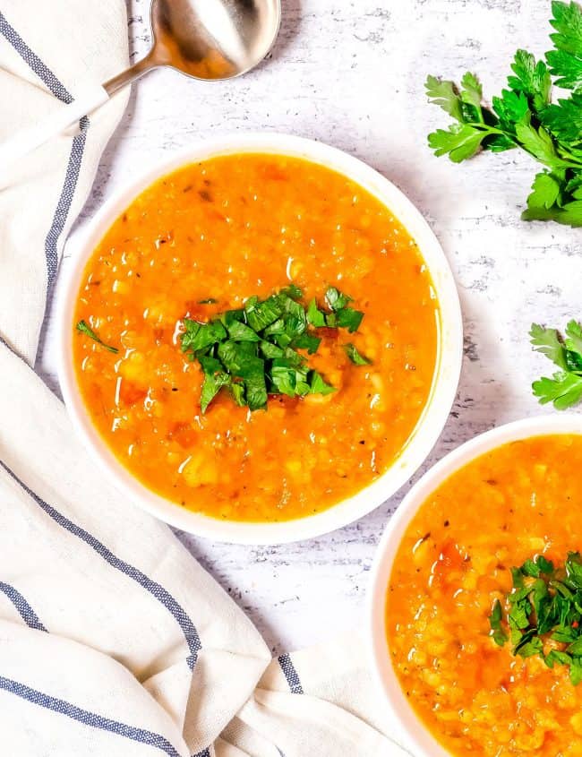 overhead shot of two bowls of red lentil soup