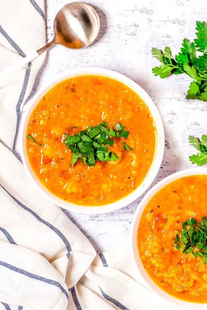 overhead shot of two bowls of red lentil soup