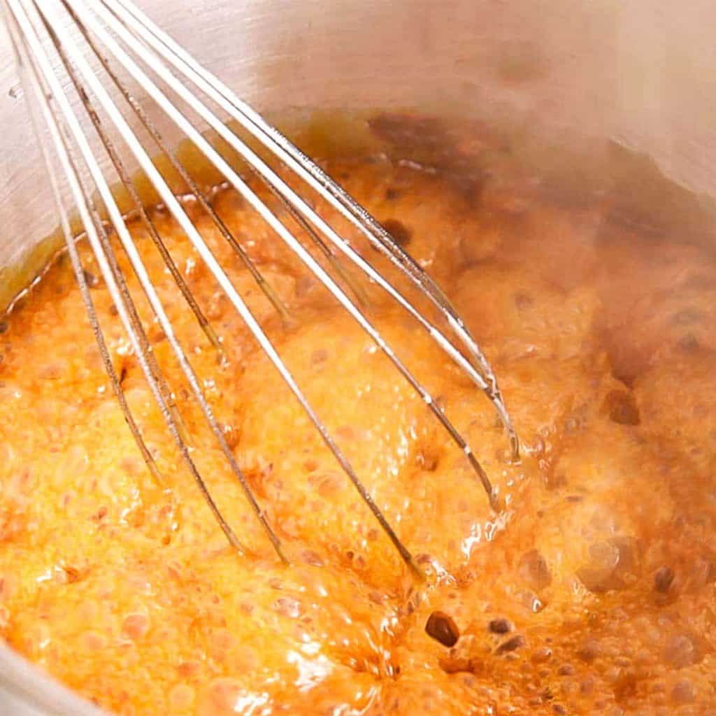 a whisk in bubbling caramel