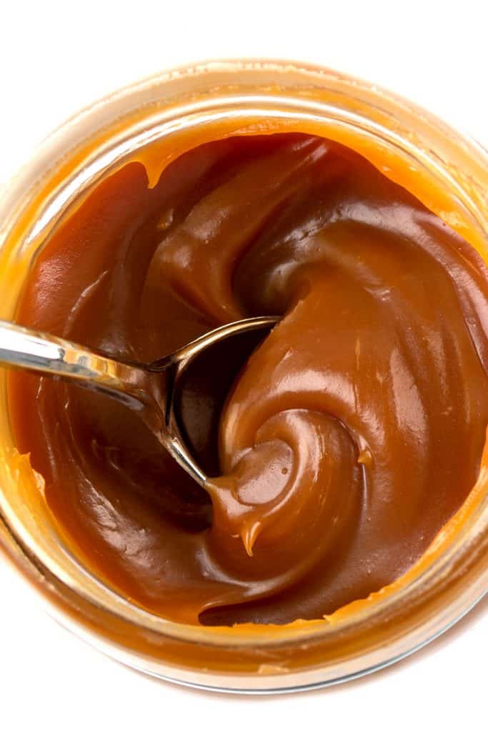 a jar of caramel from above with a spoon in it