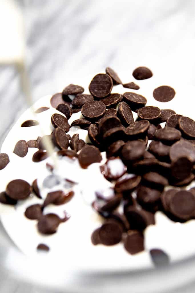chocolate chips and hot cream in a bowl