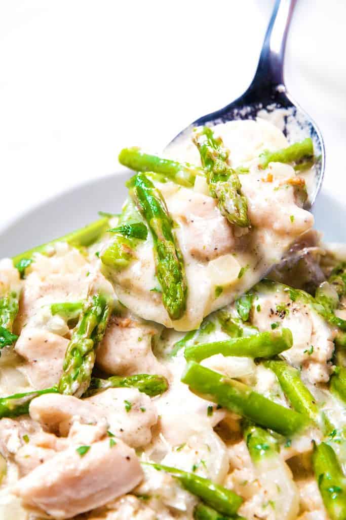 a spoon of chicken and Asparagus in a cream sauce