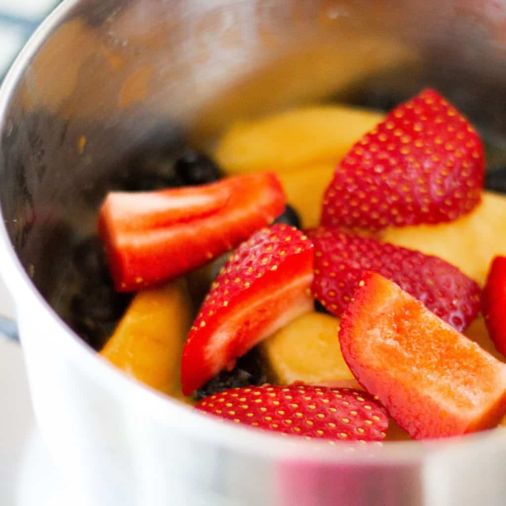 strawberries and peaches in a metal bowl