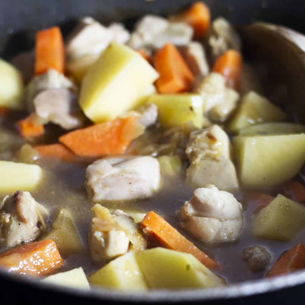 The potatoes and carrots added to the pot with the chicken