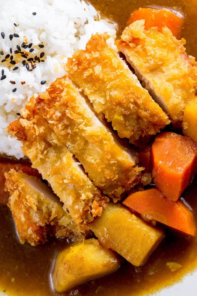 a breaded chicken cutlet served with rice and curry