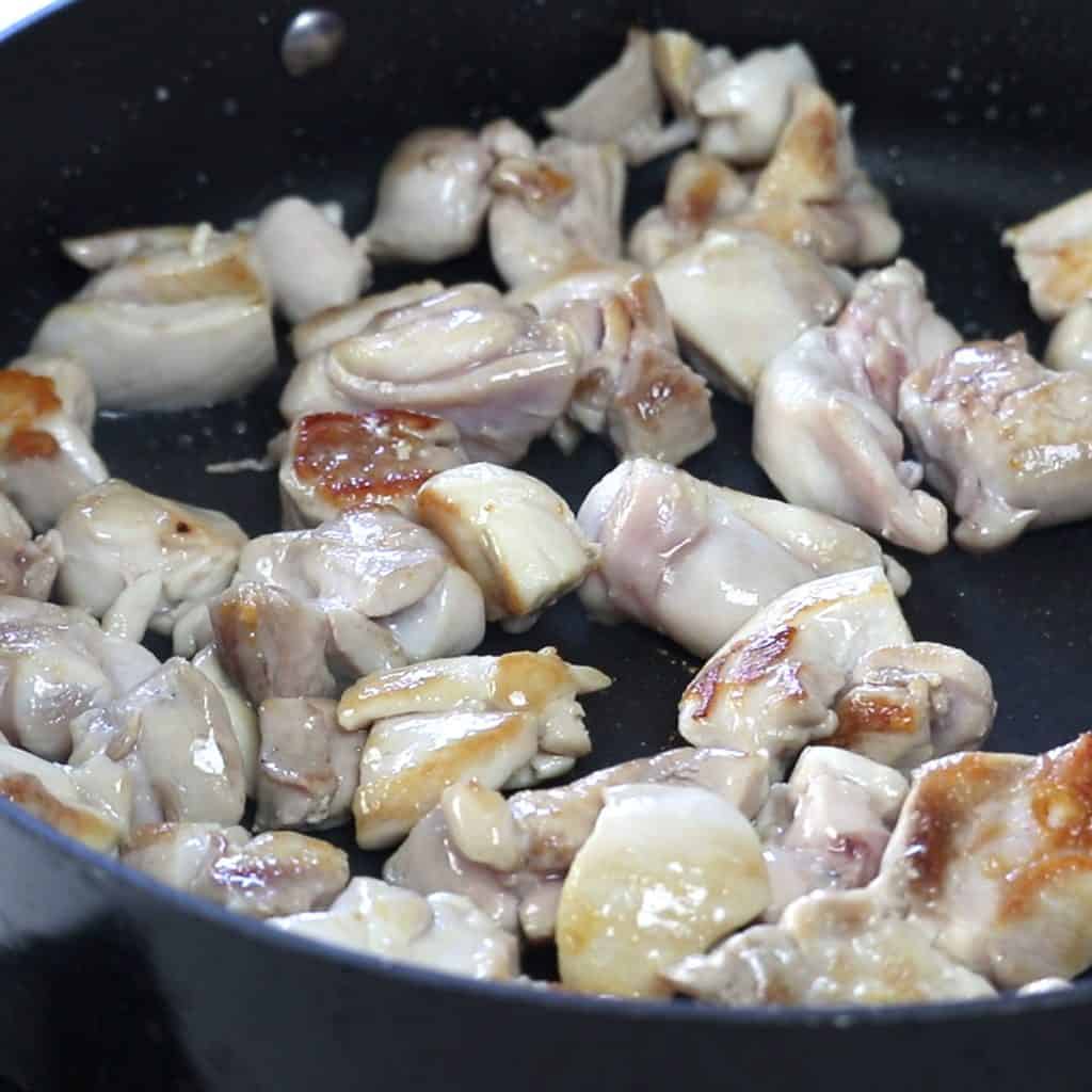 Chicken chunks browning in a pan