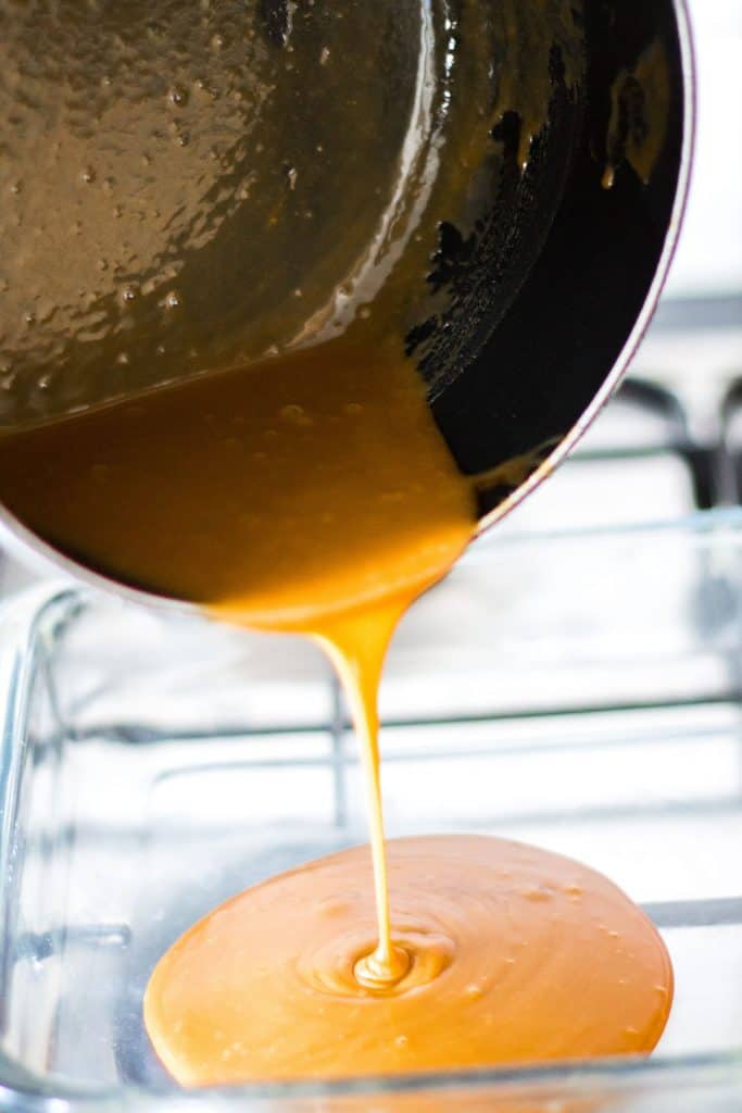 Caramel being poured into a glass dish.