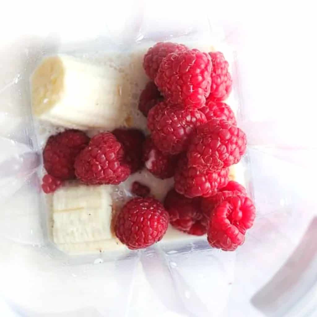 an overhead shot of chopped bananas and raspberries