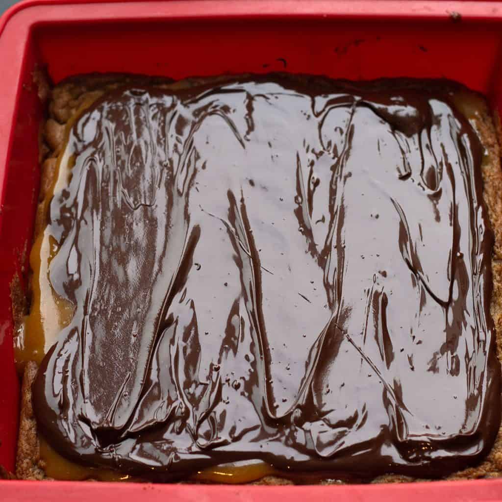 melted chocolate spread over the caramel layer