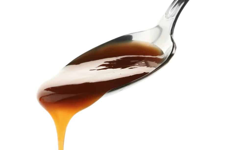 A spoon of caramel sauce