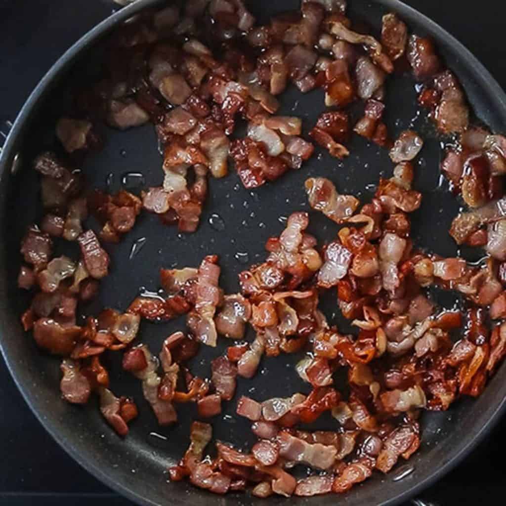 A pan with cooked, chopped bacon