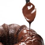 chocolate glaze being applied to a chocolate cake