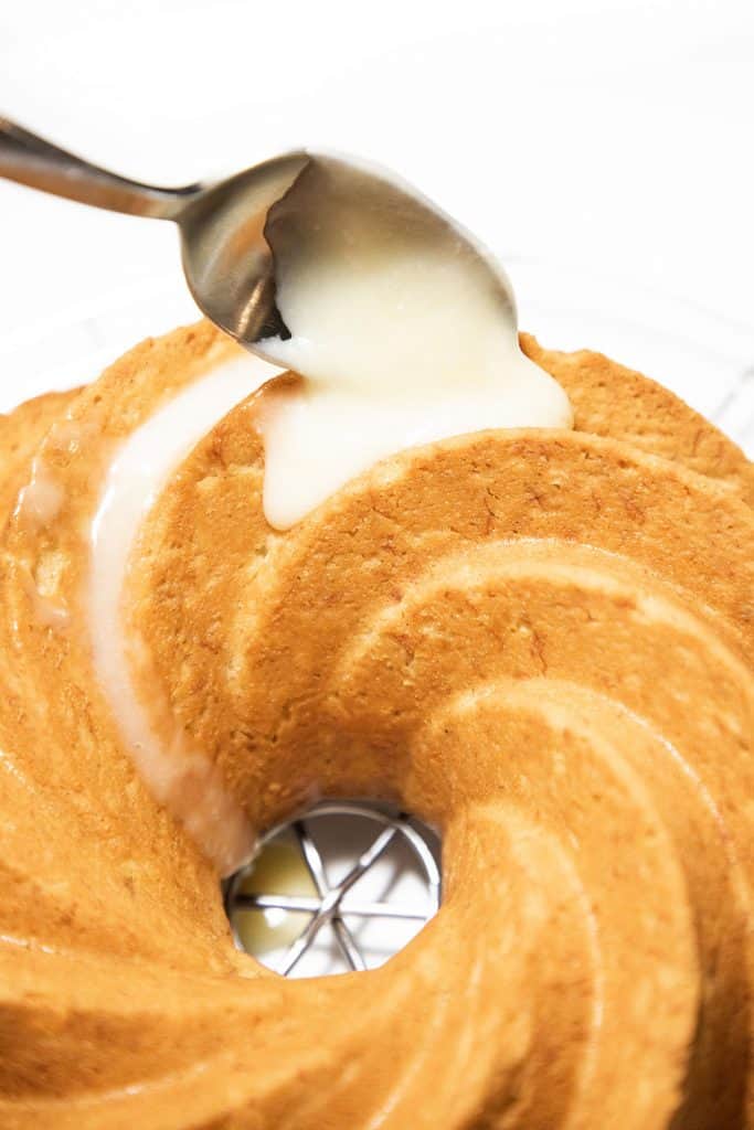 Cream Cheese Glaze being spooned onto a cake
