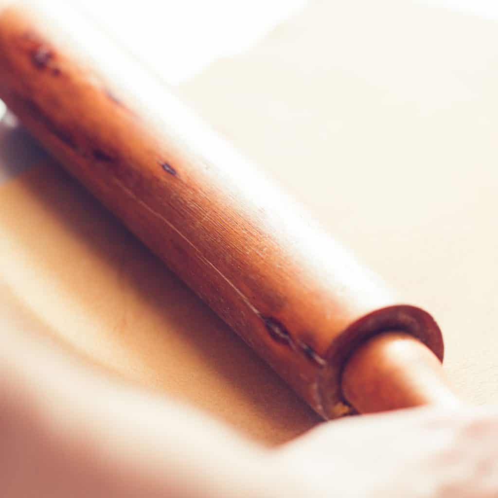 dough being rolled with a rolling pin