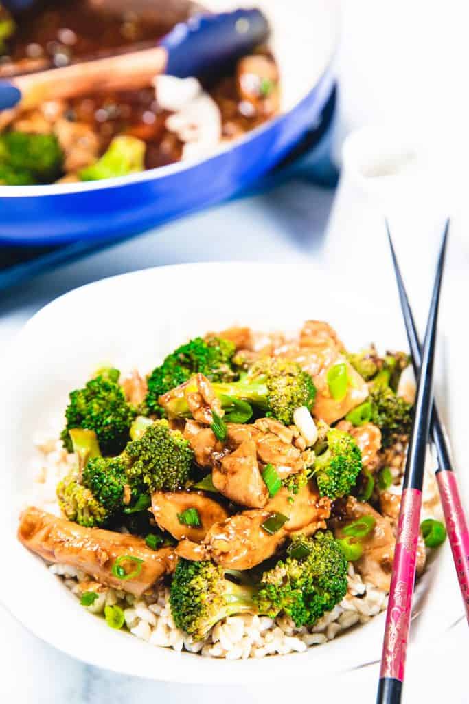A chicken and Broccoli stir fry piled high on a white plate