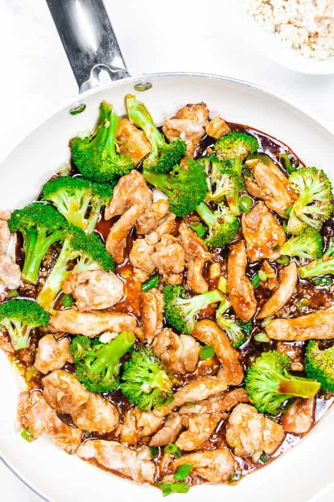 A pan with a chicken stir fry with broccoli and sauce.
