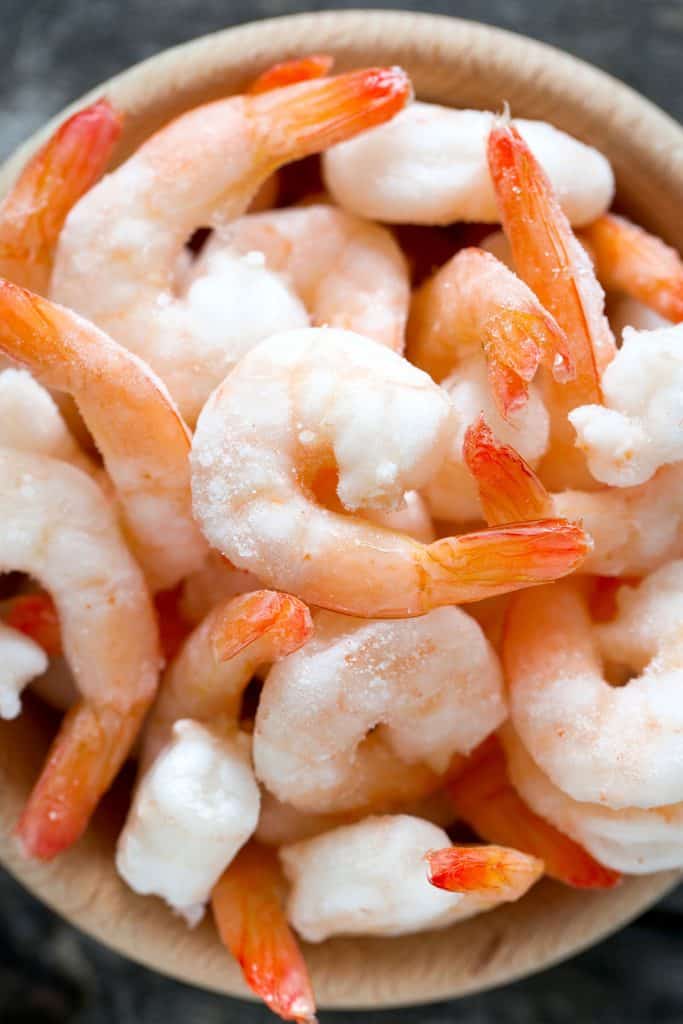 frozen shrimp in a bowl on wooden surface