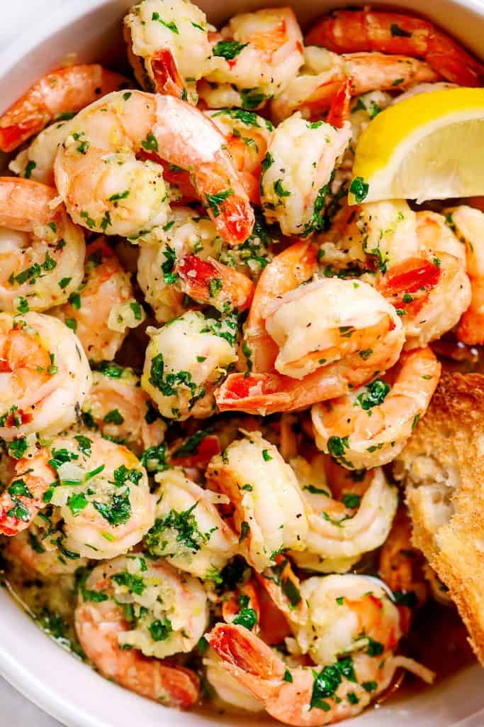 Close up of Shrimp with garlic and parsley piled high in a dish