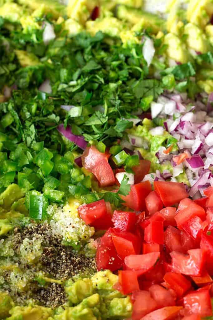 chopped tomato and cilantro added to mashed avocado