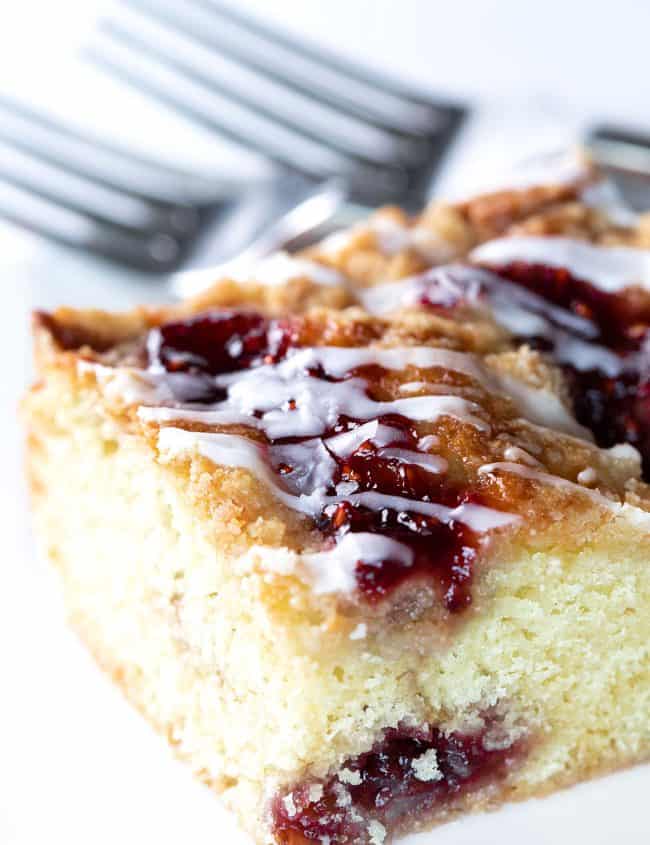 a slice of cake with rapberry jam and icing