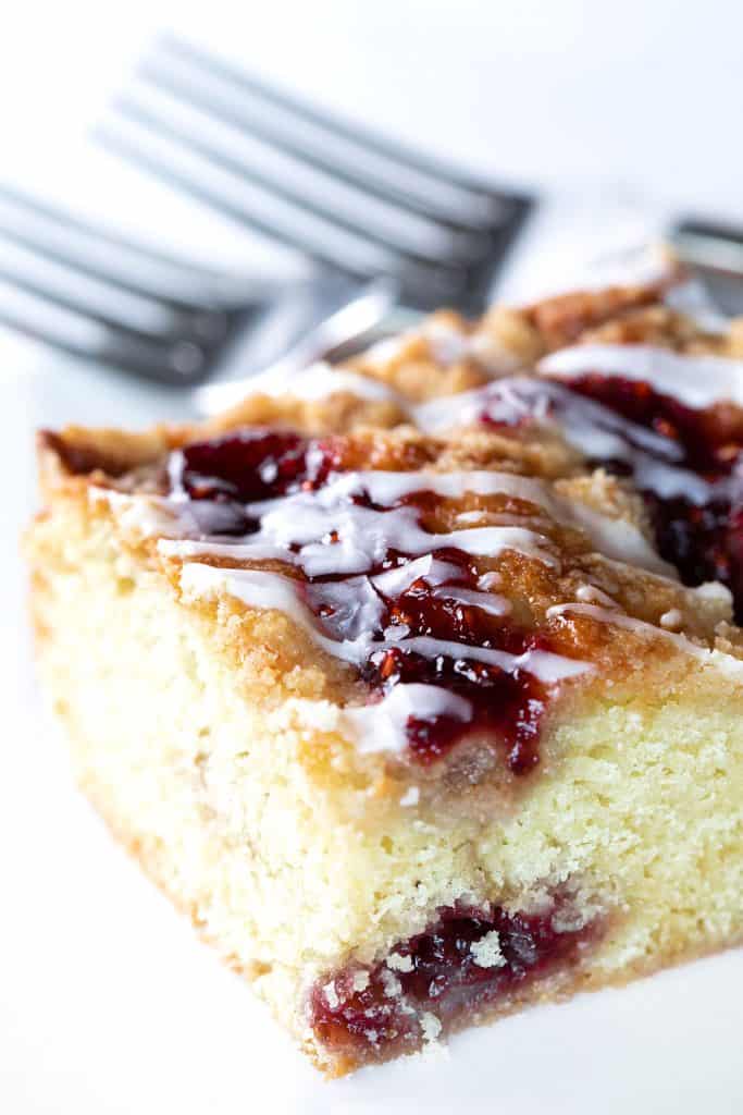 a slice of cake with rapberry jam and icing