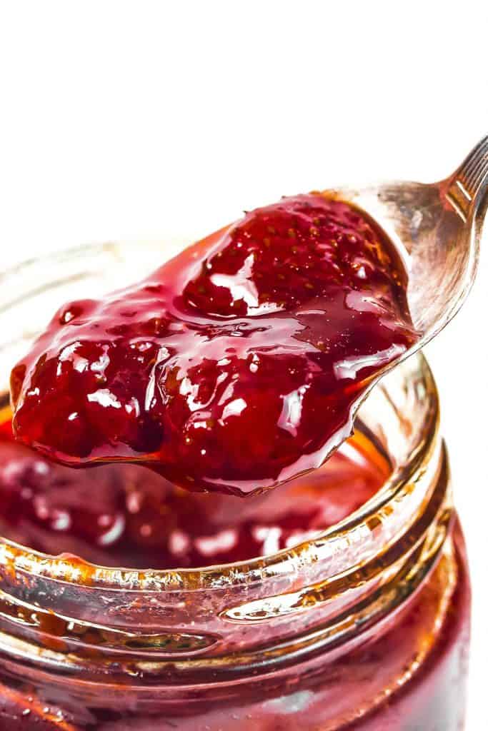 a spoonful of Strawberry Jam Preserves coming out of a jar