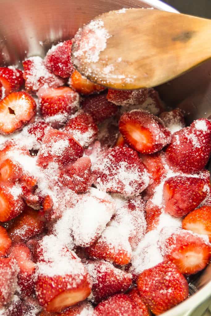 strawberries in a pan with sugar and lemon juice