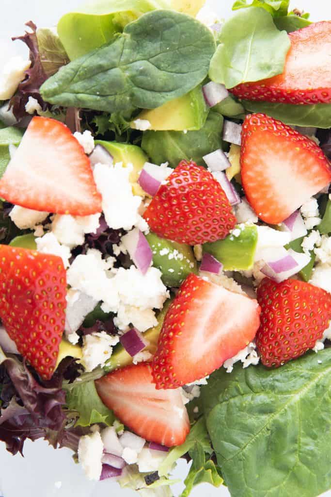 strawberries added to green salad, red onion, feta cheese and avocado