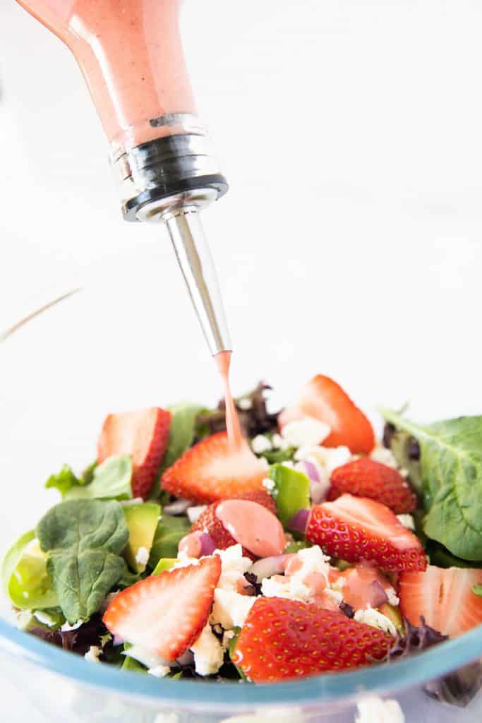 salad dressing being put onto a salad