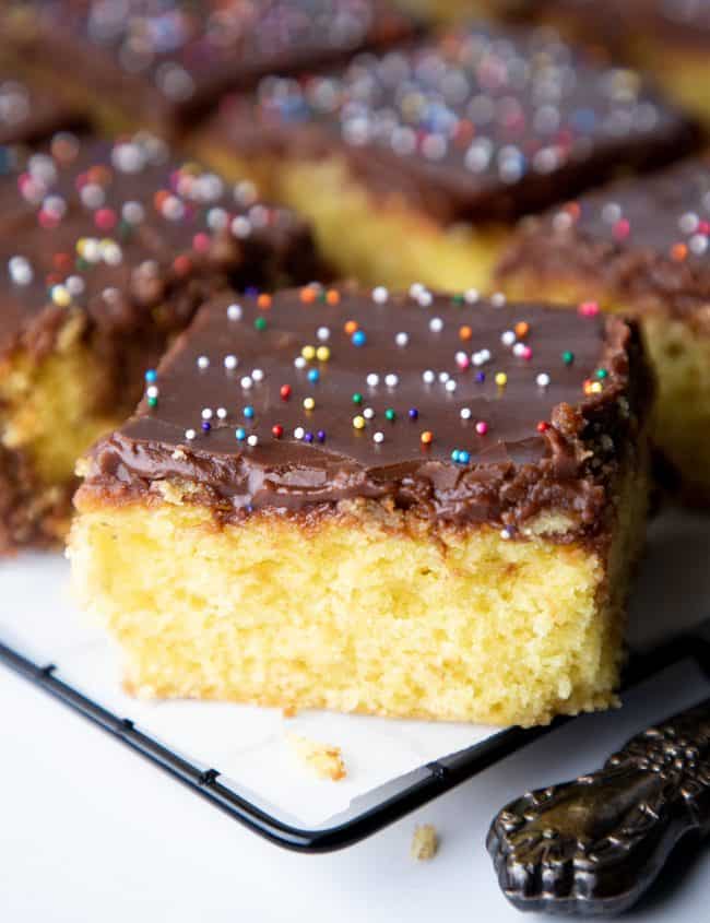 a slice of yellow cake with chocolate frosting