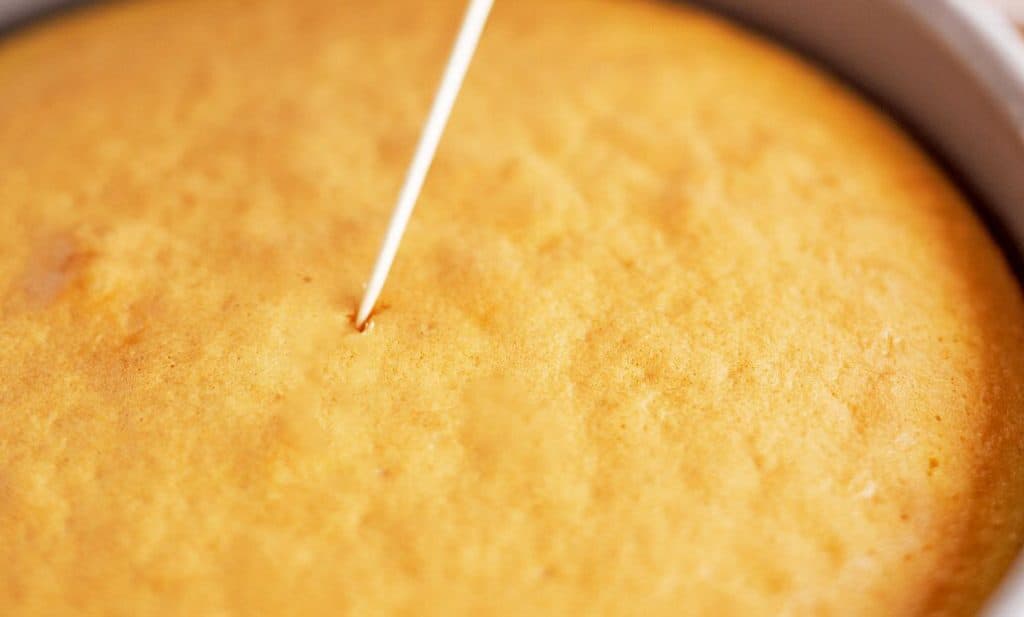a cake with a toothpick being inserted into it