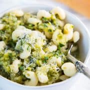 a bowl of pasta with zucchini soup with a spoon in it