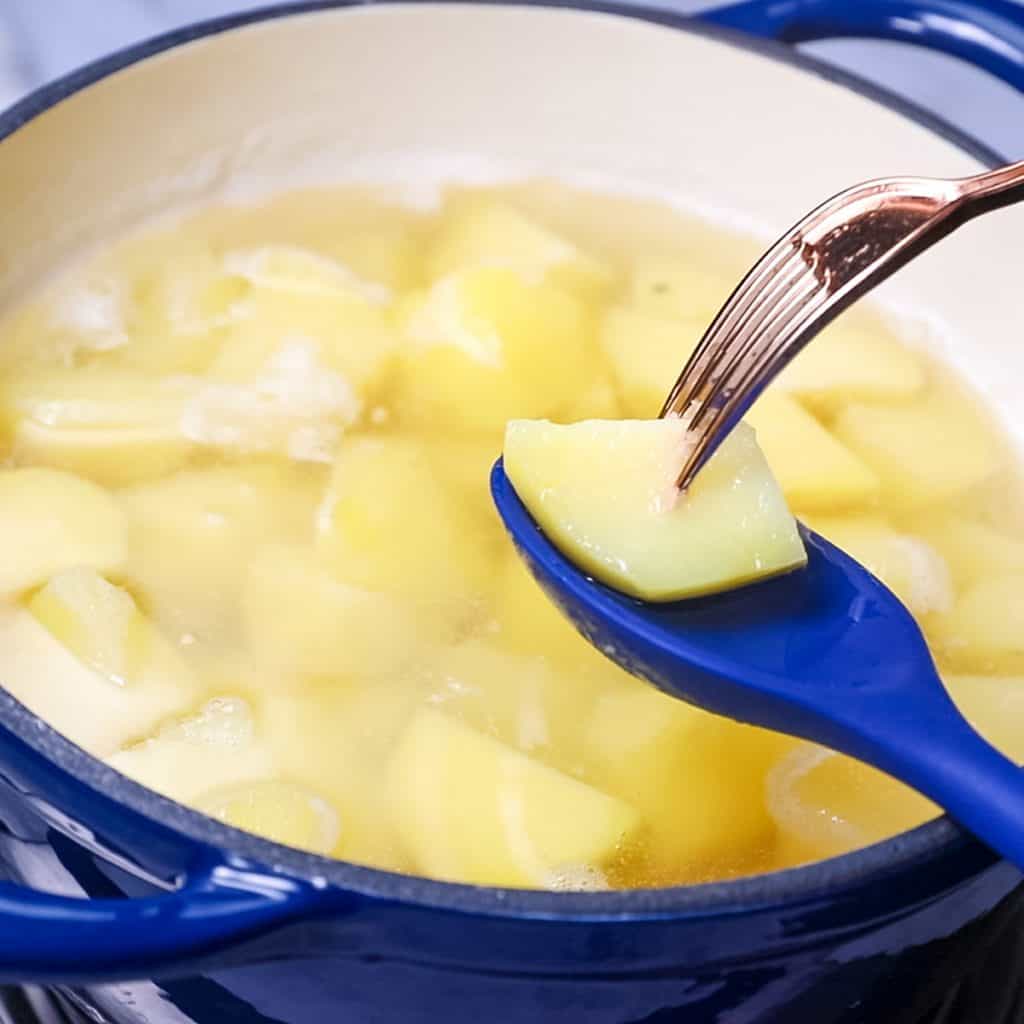 a fork testing to see if a potato is cooked