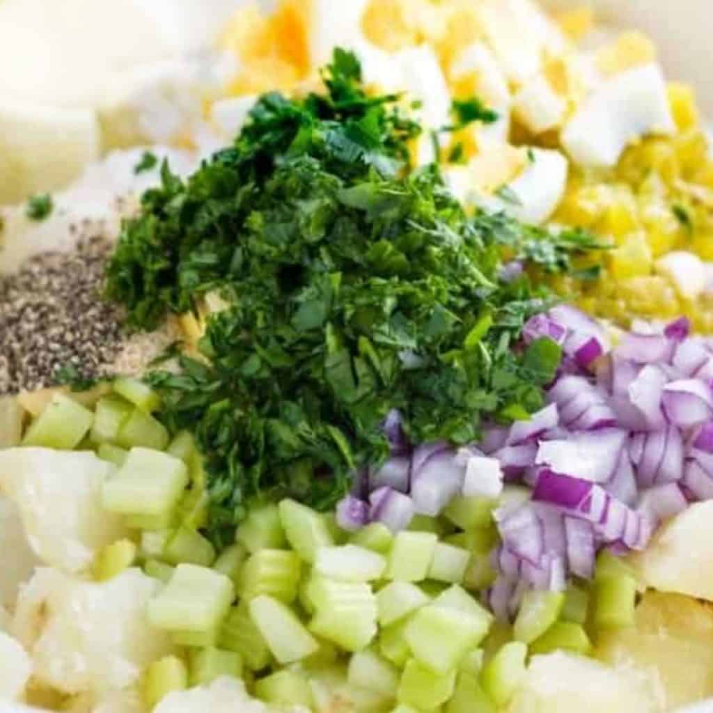potatos, celery. pickels, eggs, onions and celery in a bowl