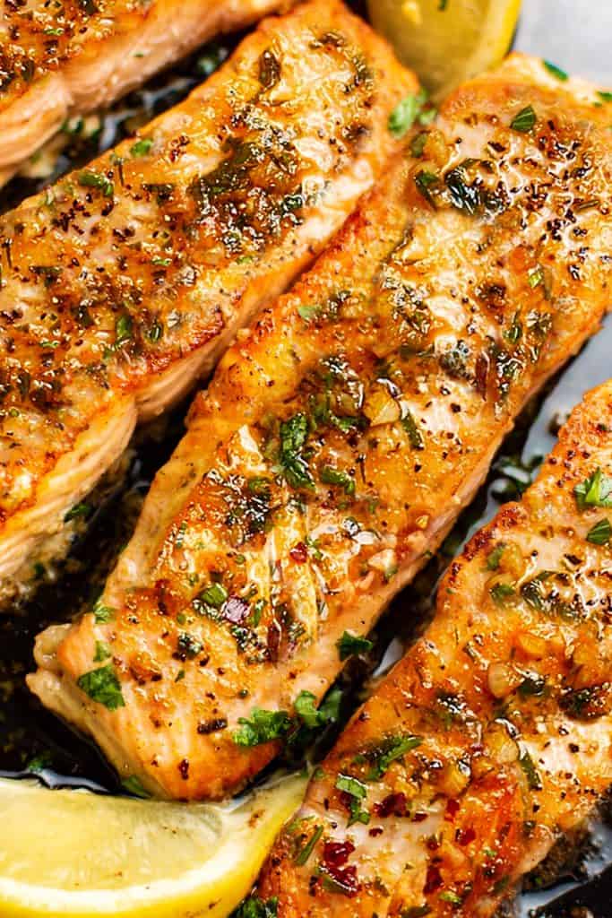 salmon basted in garlic butter with lemon wedges