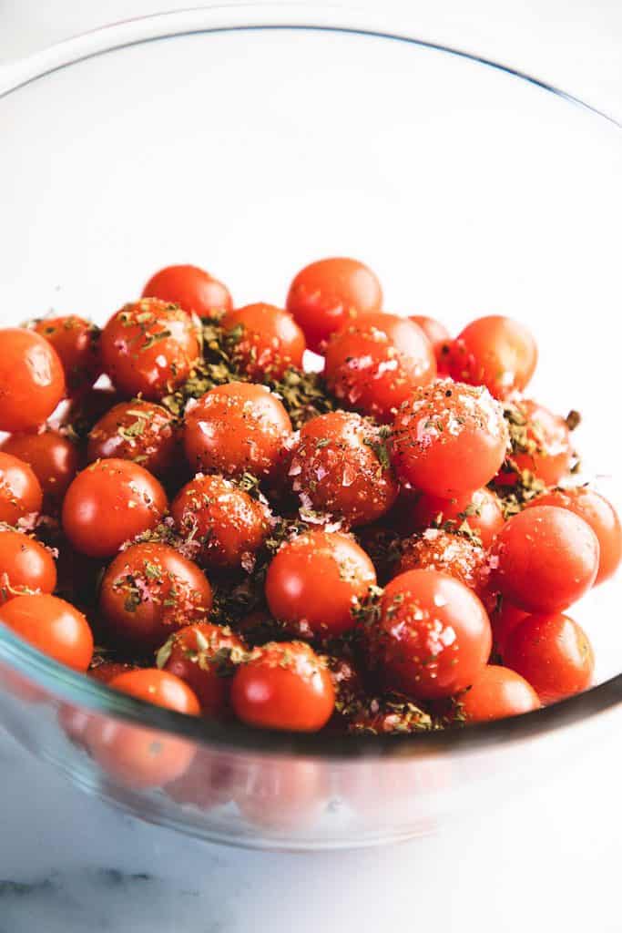 herbs on a bowl of cherry tomatoes