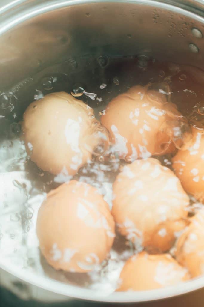 brown eggs boiling in a pot of water