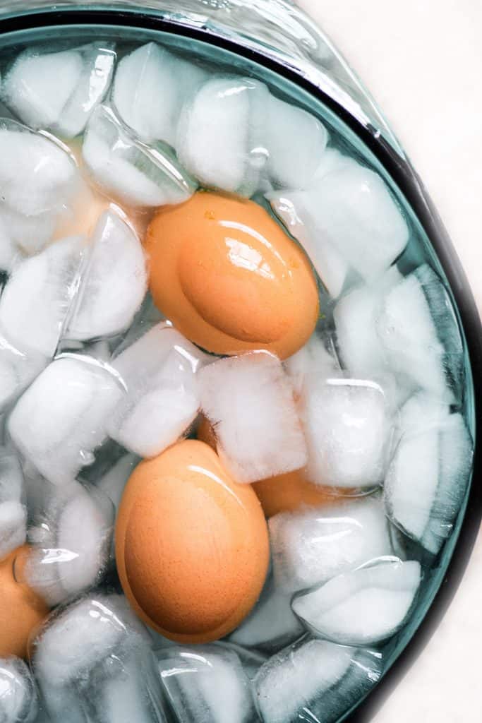 cooked eggs in a bowl of ice water
