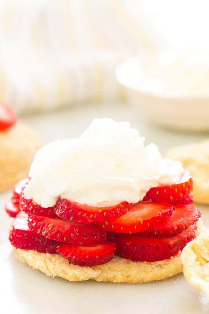 cream and strawberries on top of a biscuit