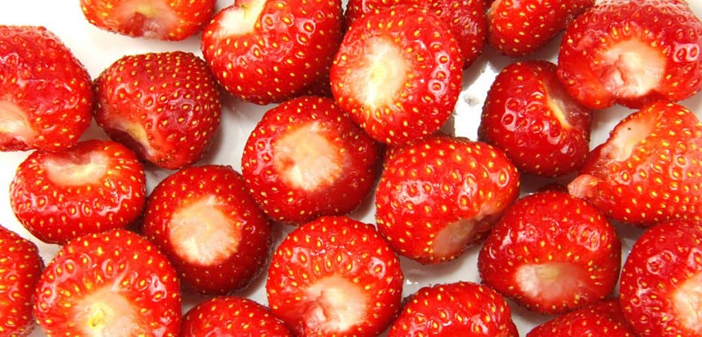 hulled strawberries on a cuttingboard